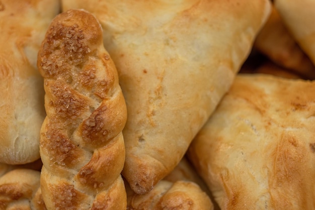 Freshly baked pies and buns with a golden crust, triangular shape and pigtail