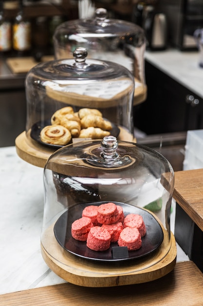 Freshly baked pile of pink color Scones inside glass dome lid. Eat with tea or coffee. Good bakes pastry.