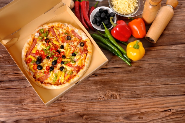 Freshly baked Pizza in delivery box with ingredients.