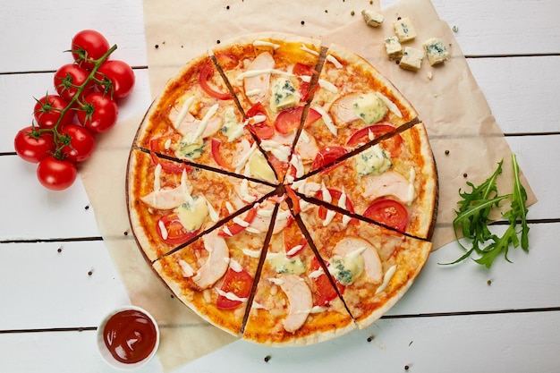 Freshly baked pizza with smoked chicken fillet and gorgonzola cheese served on wooden background with tomatoes sauce and herbs Food delivery concept Restaurant menu Top view