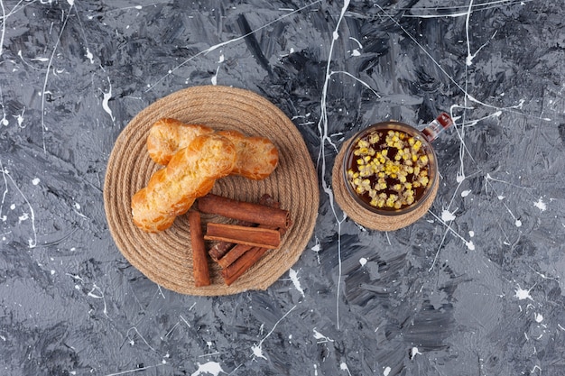 Freshly baked plain eclairs with cinnamon sticks. 