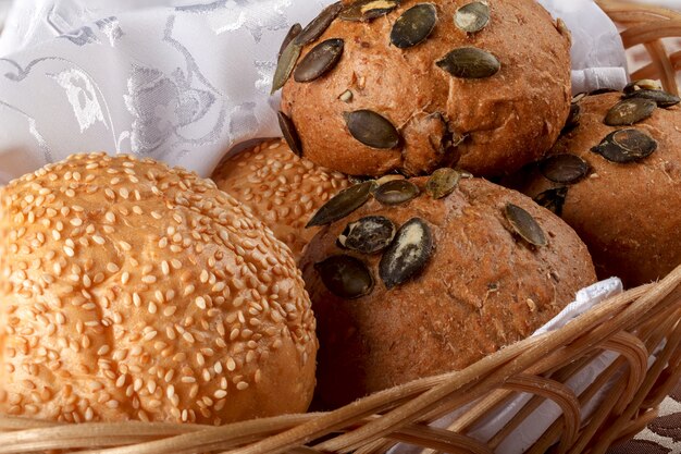 Freshly baked rolls and bread in a basket on a table.