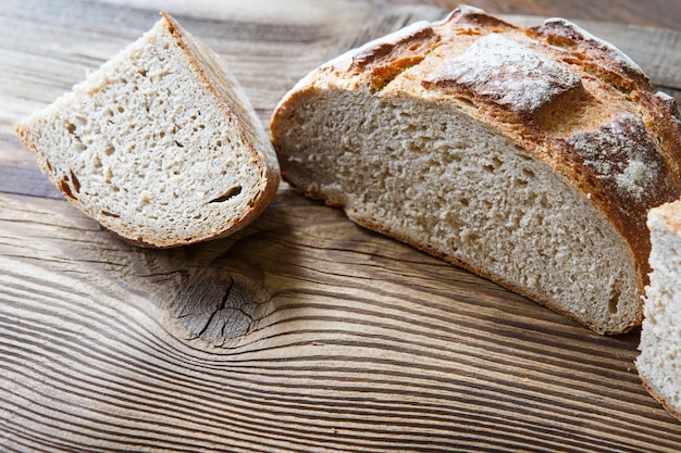 A freshly baked rustic loaf of bread on an old wooden table