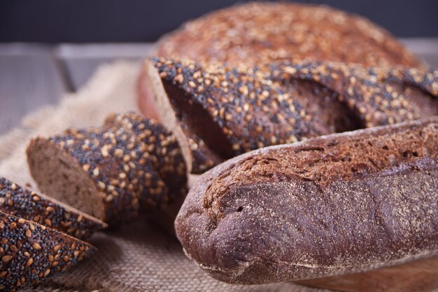 Pane di segale di recente al forno con cereale e semi sul tavolo da cucina di legno