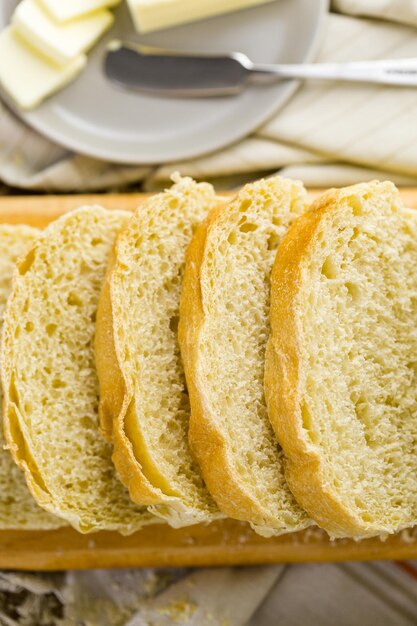 갓 구운 사워도우 빵은 커팅 보드에 얇게 썬다.