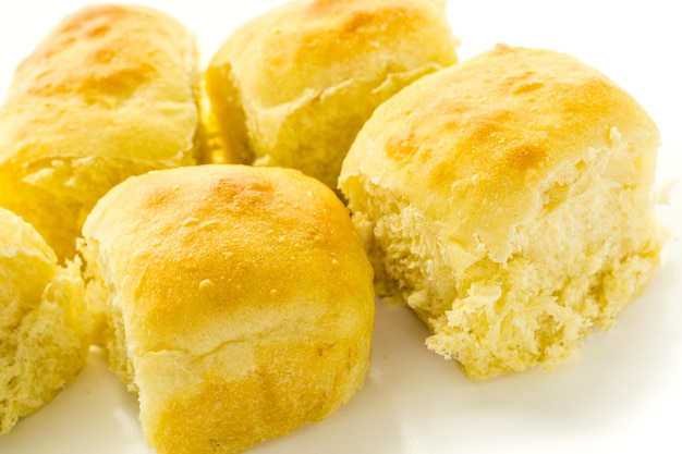 Freshly baked sourdough dinner rolls on a white background.