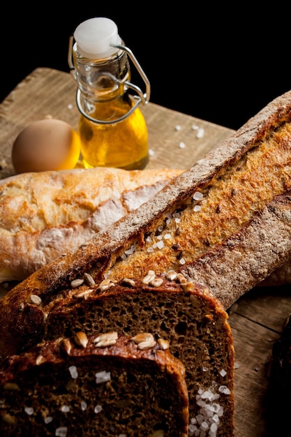 Freshly baked traditional bread with egg and sunflower oil on a wooden table baguette with salt