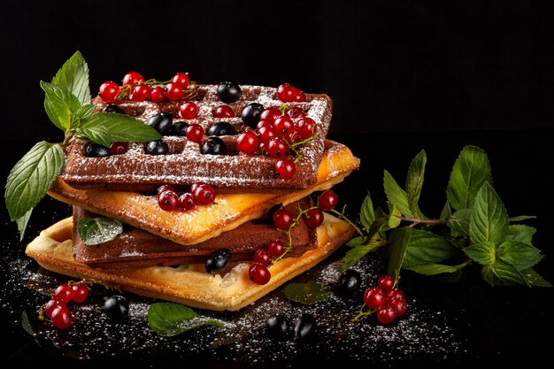 Freshly baked Viennese waffles lie on a black table.