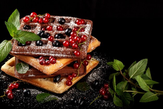 Freshly baked Viennese waffles lie on a black table.