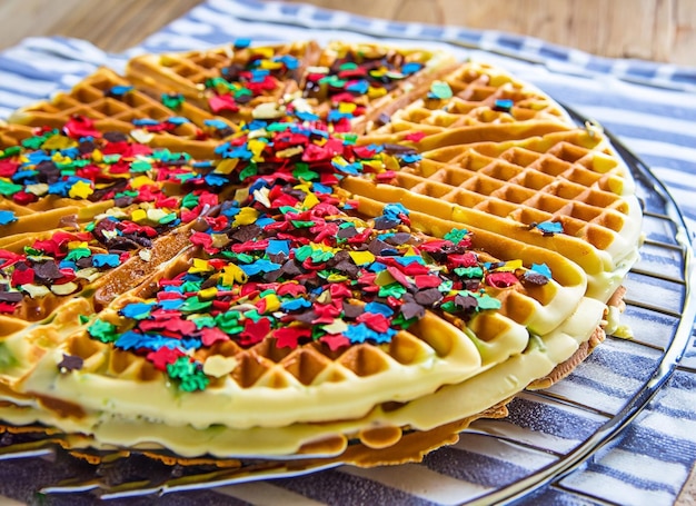 Freshly baked waffle on plate with sprinkles
