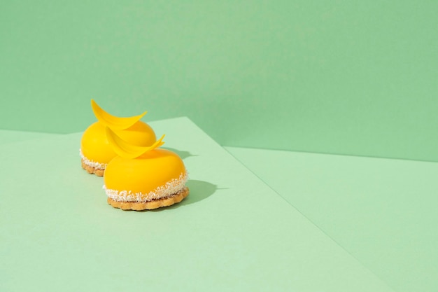 Photo freshly baked yellow cupcakes with delicious white whipped icing on top and green background