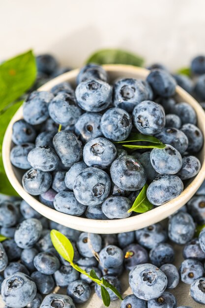 그릇에 신선한 블루베리 녹색 잎이 있는 육즙과 신선한 딸기 건강 식품 개념