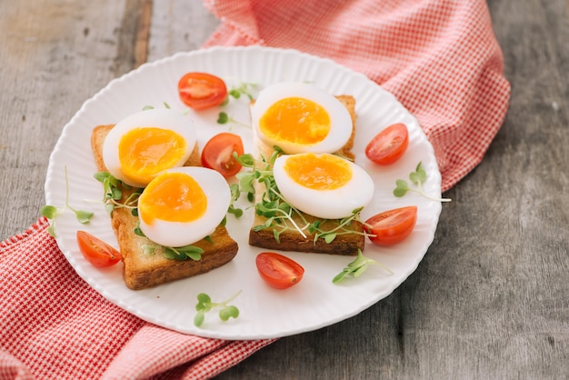 Freshly boiled white egg on wooden board. Healthy fitness breakfast.