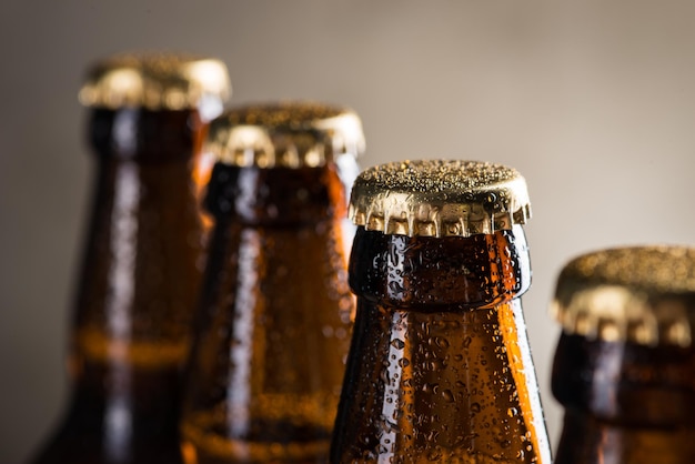 Freshly brewed beer bottles in a row over the grey concrete wall