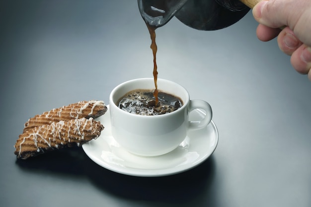 Freshly brewed black coffee from the turks poured in a white Cup
