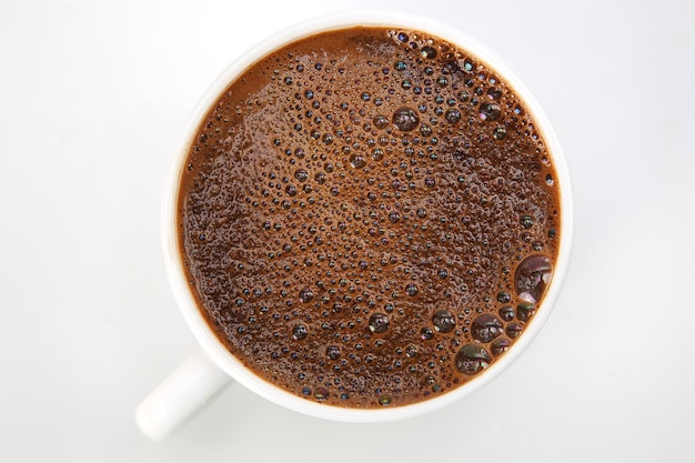 Свежезаваренный кофе в чашке на белом фоне крупным планом