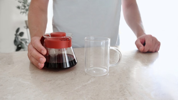 Freshly brewed coffee in glass server and glass cup on table. Pourover, V60.