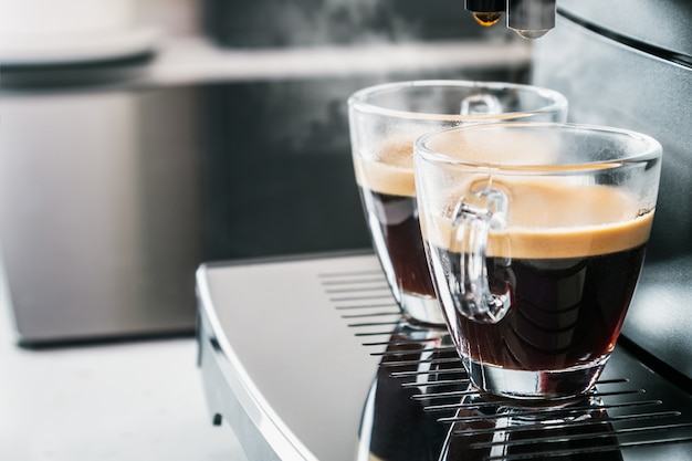 Freshly brewed coffee is poured from the coffee machine