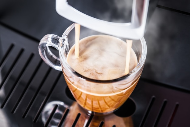 Freshly brewed coffee is poured from the coffee machine