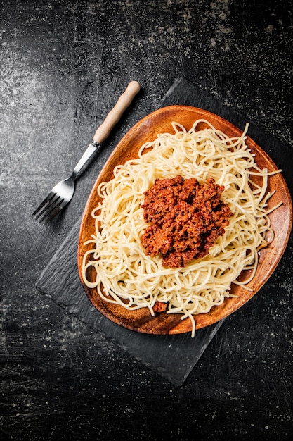 Свежеприготовленные спагетти болоньезе на черном фоне