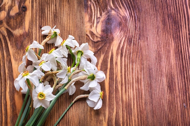 Freshly cut bunch of white narcissi on a wooden table. Copy space.