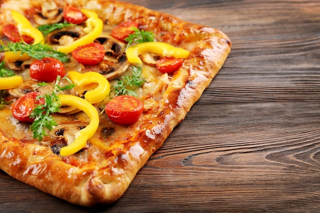 Freshly homemade pizza on wooden background