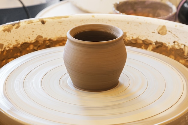 Freshly made clay pot on a potters wheel