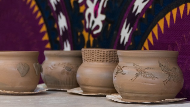 Freshly made clay pots on a decorative background. children's crafts