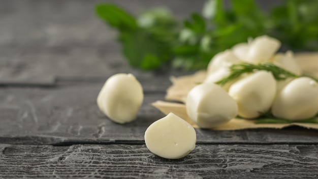 Freshly made mozzarella cheese with parsley on a wooden table