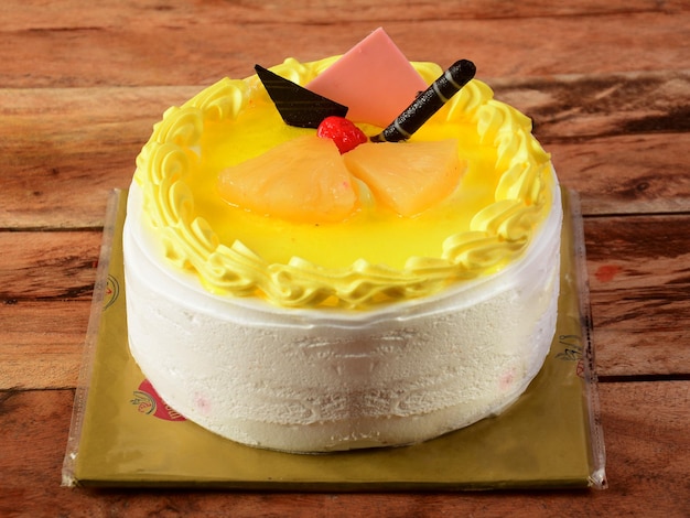 Freshly made pineapple and fresh cream cake on wooden table selective focus