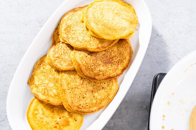 Foto frittelle di zucca appena fatte su un piatto da portata bianco