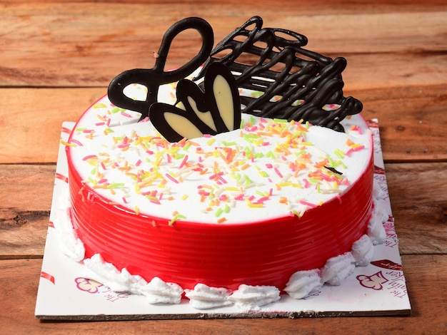 나무 테이블 선택적 초점에 갓 만든 빨간 장미 크림 케이크