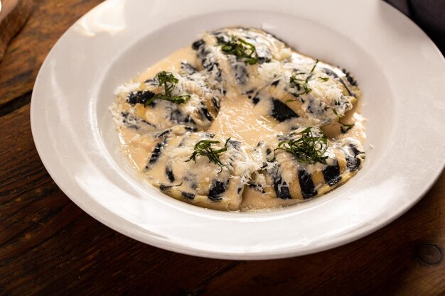 Foto ravioli di frutti di mare e formaggio appena preparati con salsa cremosa