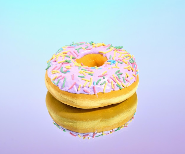 На поверхности лежит свежеприготовленный мягкий сладкий пончик с многоцветными посыпаниями