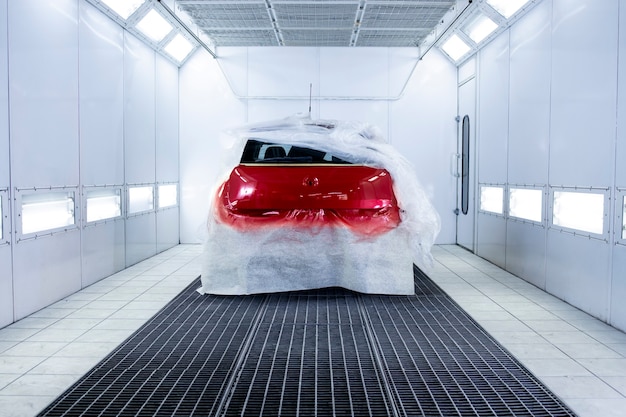 Freshly painted car drying in painting chamber.