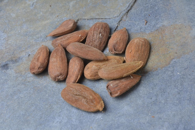 Freshly picked almonds from the tree photographed in study on a slate stone slab.