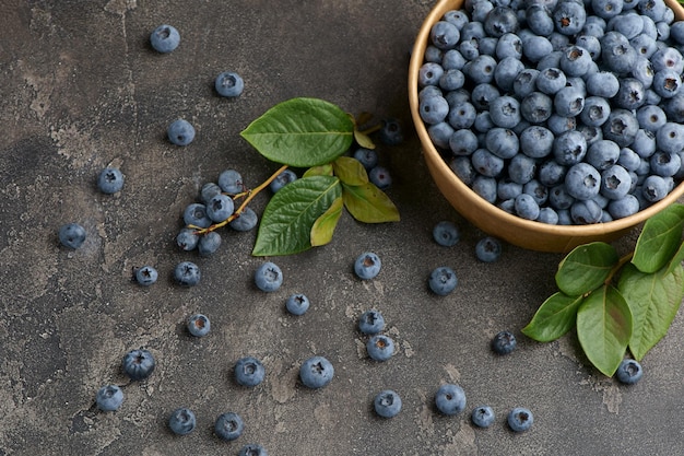 Freshly picked blueberries in a wooden bowl on a wooden background Healthy food and nutrition