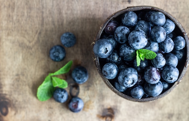 Freshly picked blueberries in wooden bowl. 