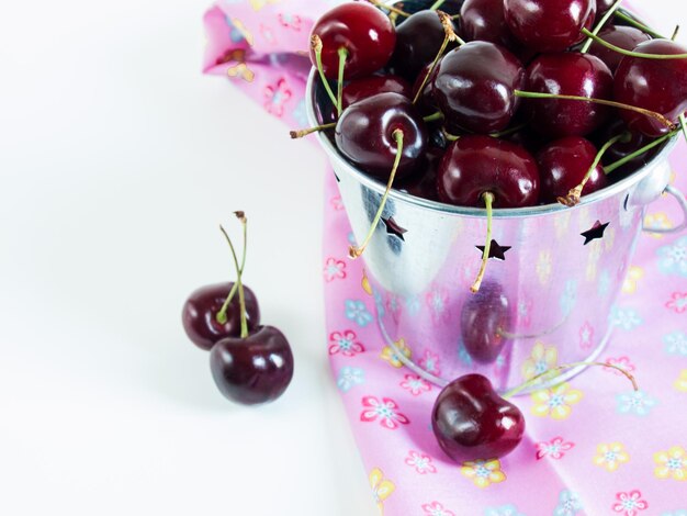 Freshly picked heap of cherries in metal bucket.