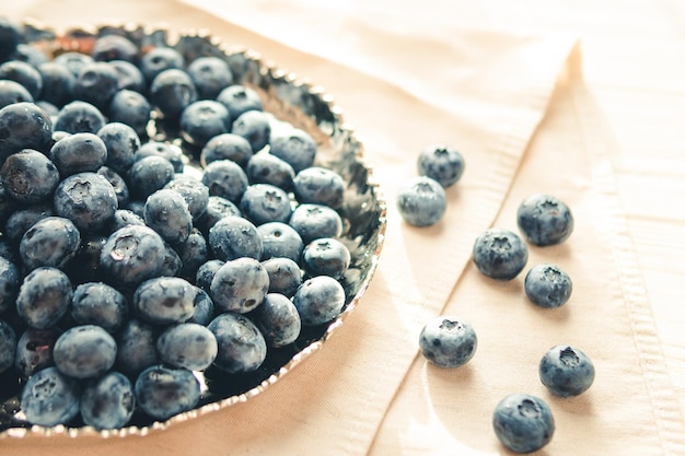 Freshly picked juicy blueberries in the bowl on wooden background close up Blueberries background