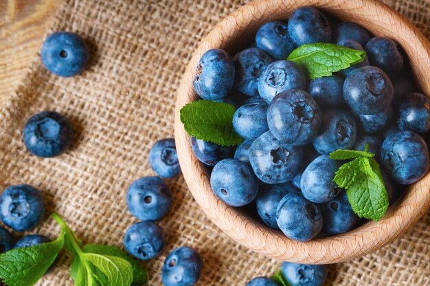 Freshly picked juicy and fresh blueberries with green mint leaves