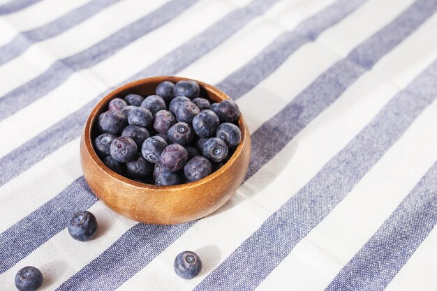 Freshly picked juicy and fresh blueberries in a wooden bowl on a rustic table Antioxidant from blueberries The concept of healthy eating