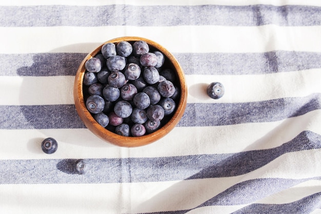 Freshly picked juicy and fresh blueberries in a wooden bowl on a rustic table Antioxidant from blueberries The concept of healthy eating