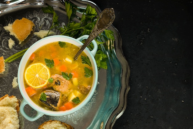 Zuppa di pesce in scatola preparata al momento con una fetta di limone su un vassoio d'argento