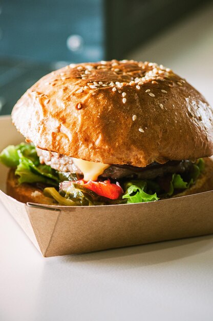 Freshly prepared cheeseburger in paper box readt to eat Takeaway and delivery concept
