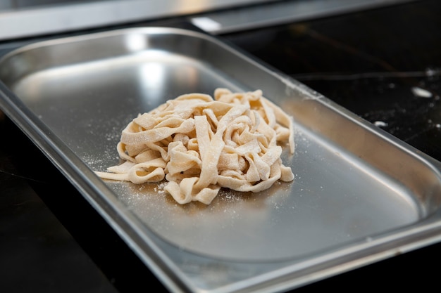 Freshly prepared portion of homemade pasta on metal tray.