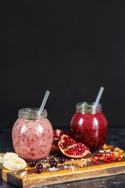 Freshly prepared smoothies from banana with pomegranate and banana with blackberry in bottle. Diet, healthy lifestyle