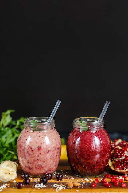 Freshly prepared smoothies from banana with pomegranate and banana with blackberry in bottle. Diet, healthy lifestyle