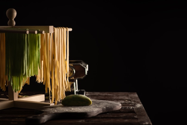 Freshly prepared tagliatelle paste is dried on a wooden drier, traditional italian cuisine