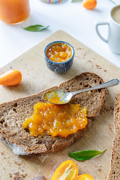 Freshly served slice of bread with orange marmalade ready for a delicious breakfast